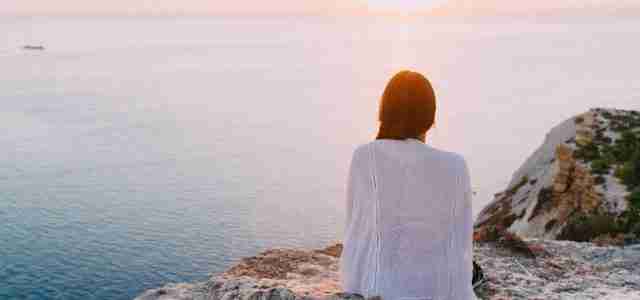 woman on rock looking over sea