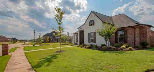 large white and brown house with big front garden