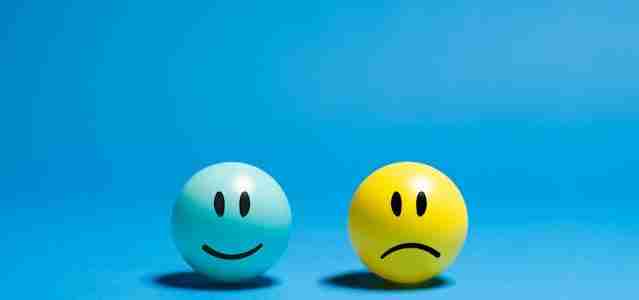 happy and sad faces on balls on blue background