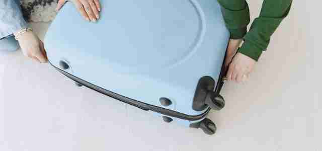 women closing suitcase