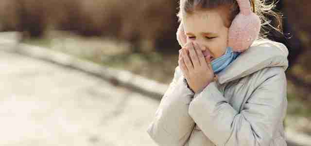 child in coat and ear muffs on cold day