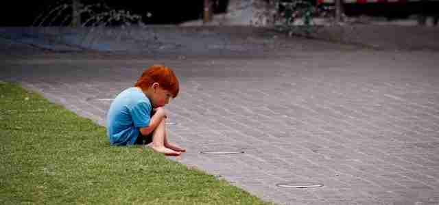 sad child sitting on ground